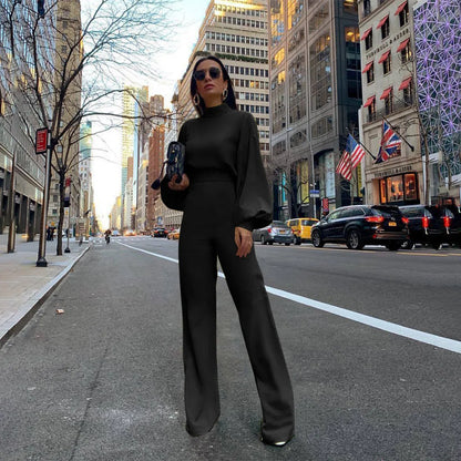 Full-length view of a sophisticated black jumpsuit, emphasizing its luxurious fabric and contemporary design ideal for stylish autumn/winter outings.