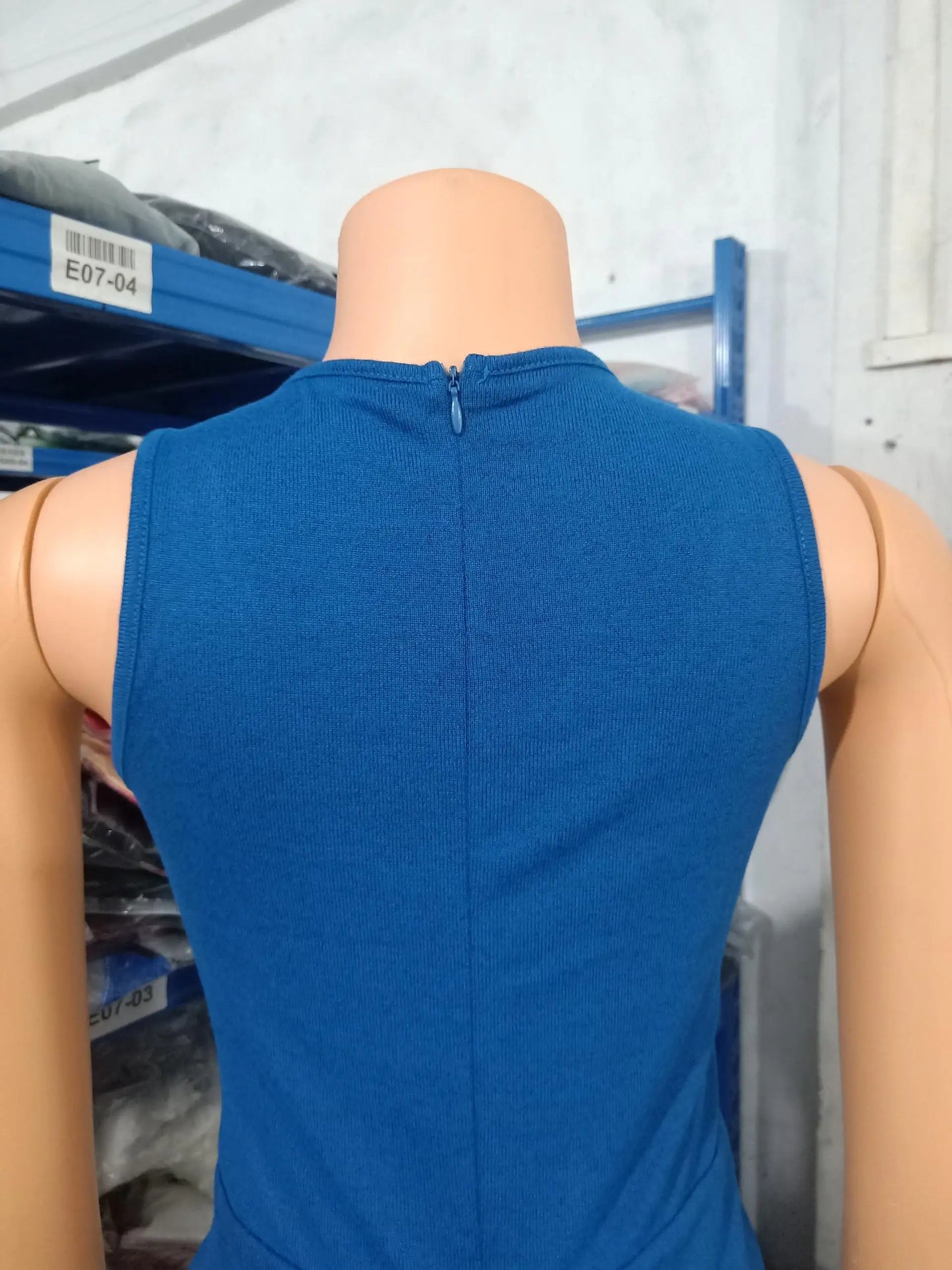 Fashionable model showcasing a stylish two-piece jumpsuit set with a sleeveless top and long sleeve coat, perfect for high street fashion lovers.