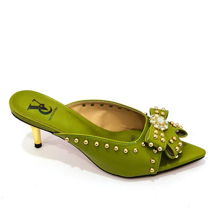 Close-up of the sleek pointed toe design of luxury women's pumps featuring a high heel and rivet details.