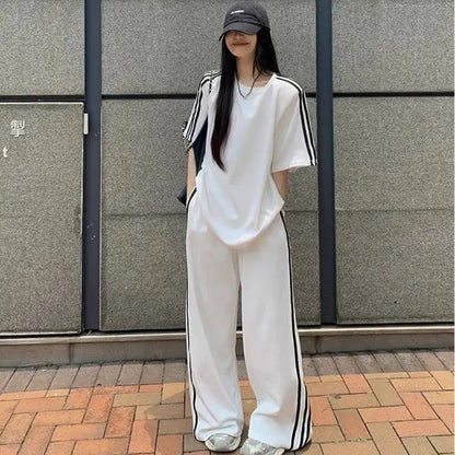 Model wearing the luxury women's casual two-piece set, displaying a chic combination of striped T-shirt and high-waisted wide leg pants that exude elegance and comfort.