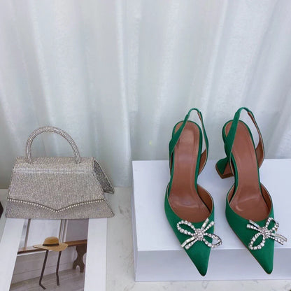 Close-up of luxury women's pointed toe sandals adorned with rhinestone bows, showcasing exquisite craftsmanship and stylish metal decorations.