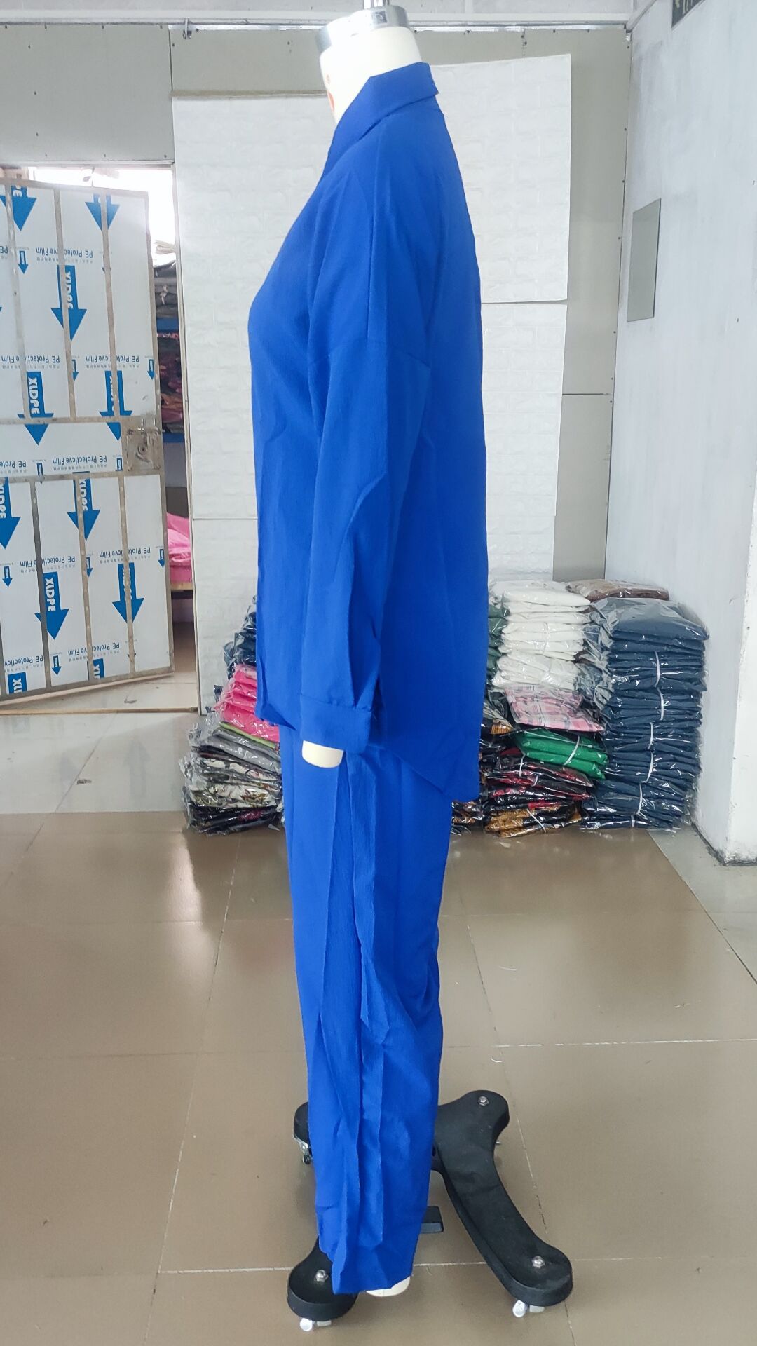 Full view of a stylish loose elastic shirt complemented by wide leg pants for a chic spring/summer look.