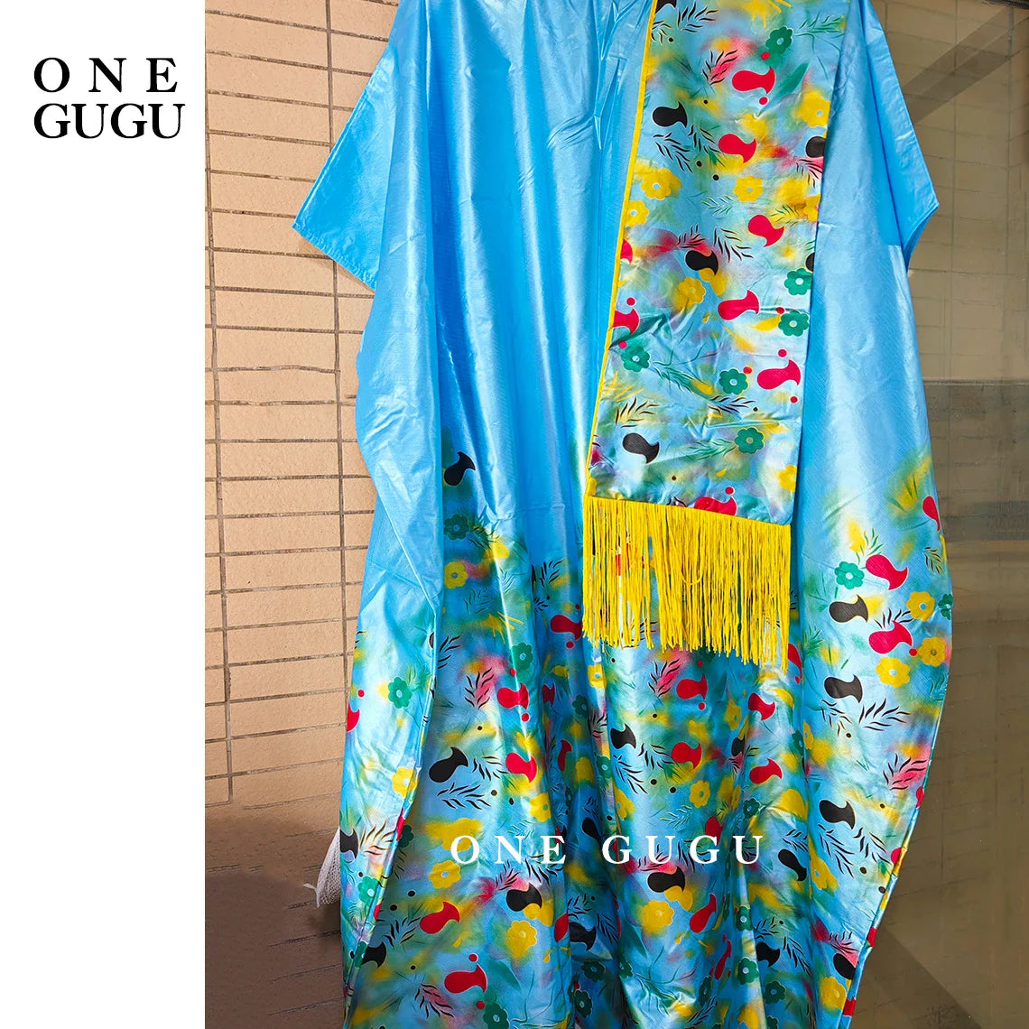 Close-up detail of embroidered lace and stones on a luxury blue Dashiki wedding dress, epitomising traditional African elegance.