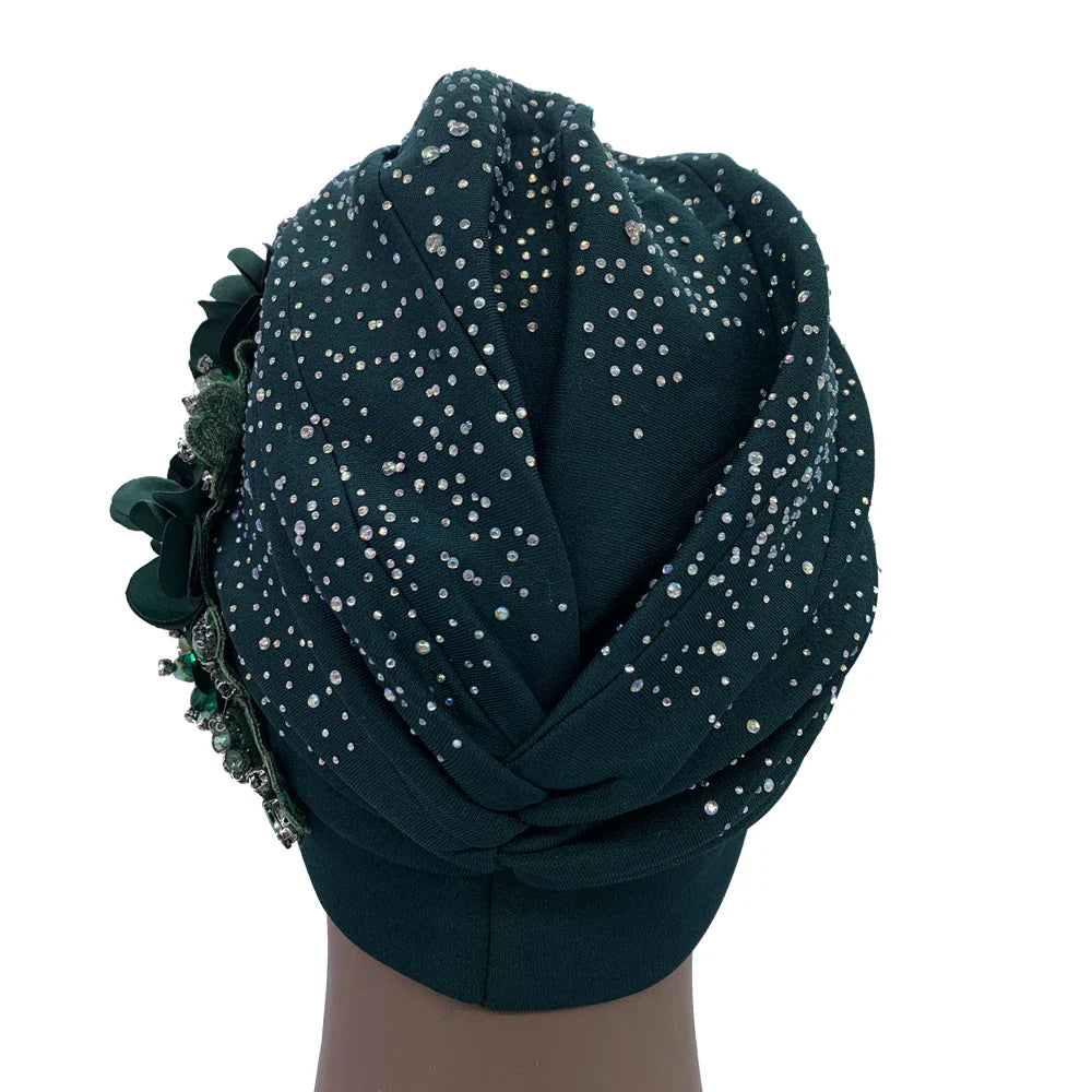 Stylish woman wearing an elegant African turban cap featuring rhinestones, epitomising luxury fashion and cultural elegance.