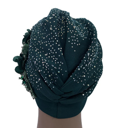 Stylish woman wearing an elegant African turban cap featuring rhinestones, epitomising luxury fashion and cultural elegance.