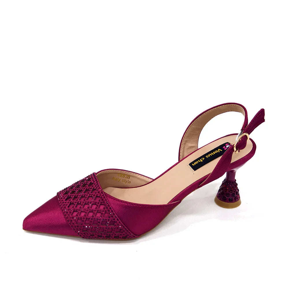 Graceful handbag with metal handle, designed for women to complement their fashionable footwear at formal events.