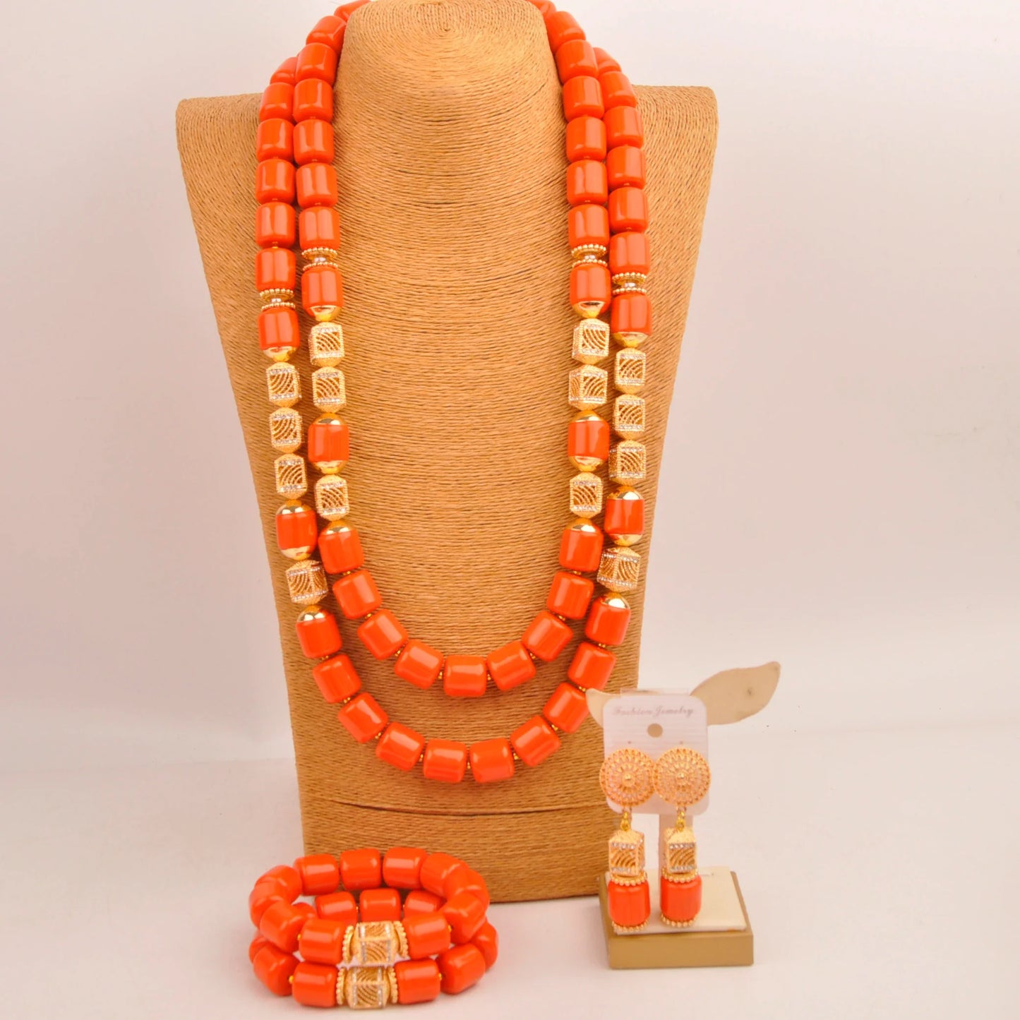 Complete Nigerian bridal jewelry set displayed elegantly, featuring a necklace, bracelet, and earrings, all adorned with luxurious artificial coral beads.