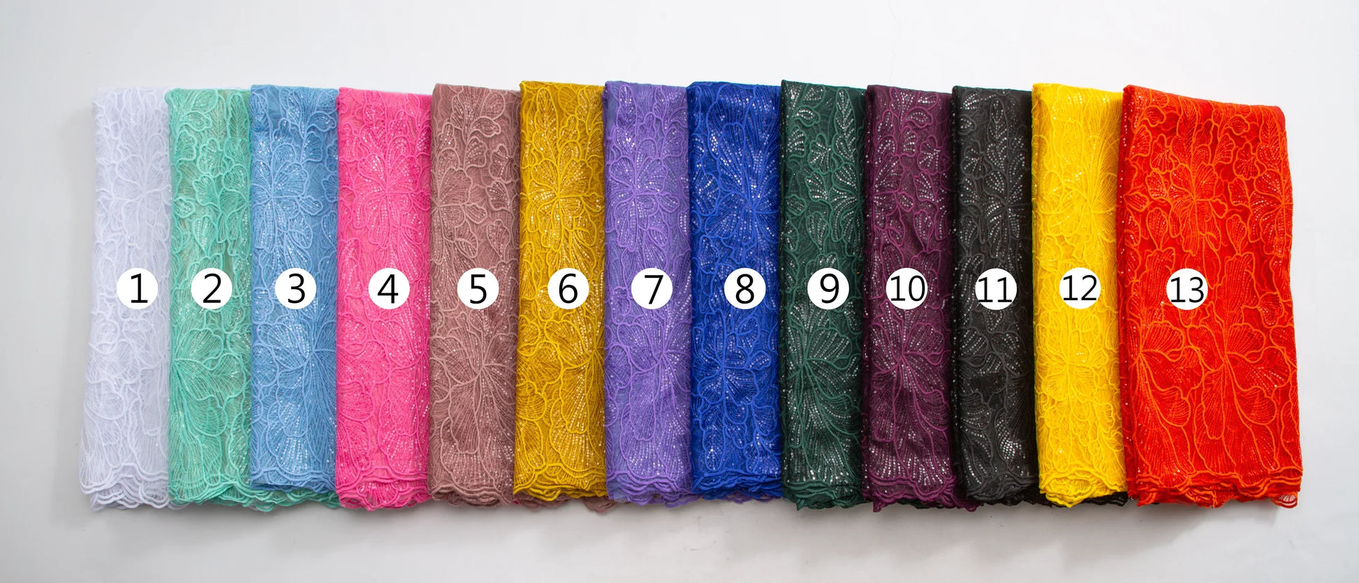 Stunning embroidered tulle fabric with sequins, perfect for lavish wedding gowns, demonstrating the vibrant elegance of African silk lace craftsmanship.