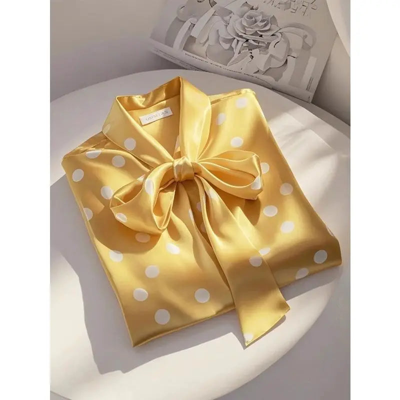 Loose fit satin blouse adorned with a stylish lace-up bow and polka dots, embodying a luxurious office fashion.