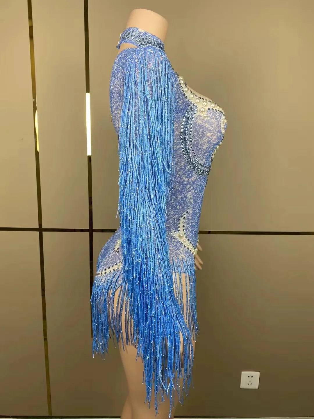Elegant model wearing a luxury women's cha-cha dance suit, highlighting the sleek silhouette and glamorous fringe accents.