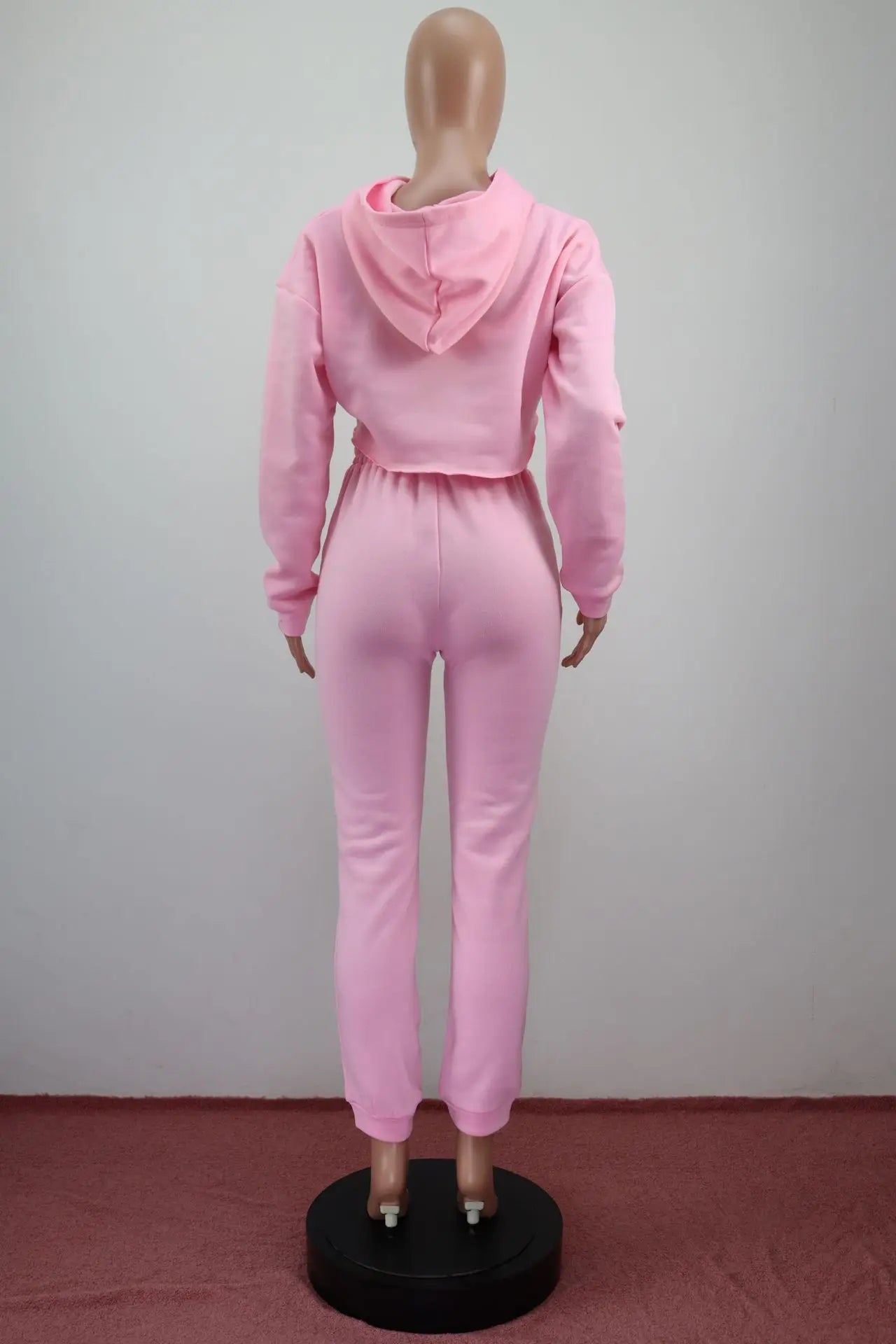 Stylish flat lay of the women's pink fleece running set, featuring the cropped hoodie and joggers, perfect for winter workouts.