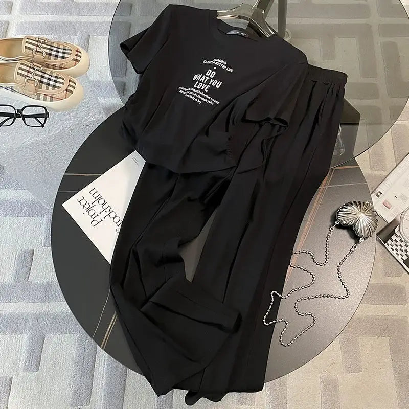 Graceful women's summer wear comprising a relaxed-fit short sleeve top and elegant wide leg pants in a timeless solid shade.