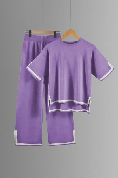 Sophisticated styling of a women's knitted trousers suit, featuring ankle-length wide-leg pants and a graceful short-sleeved pullover, ideal for a luxurious summer wardrobe.