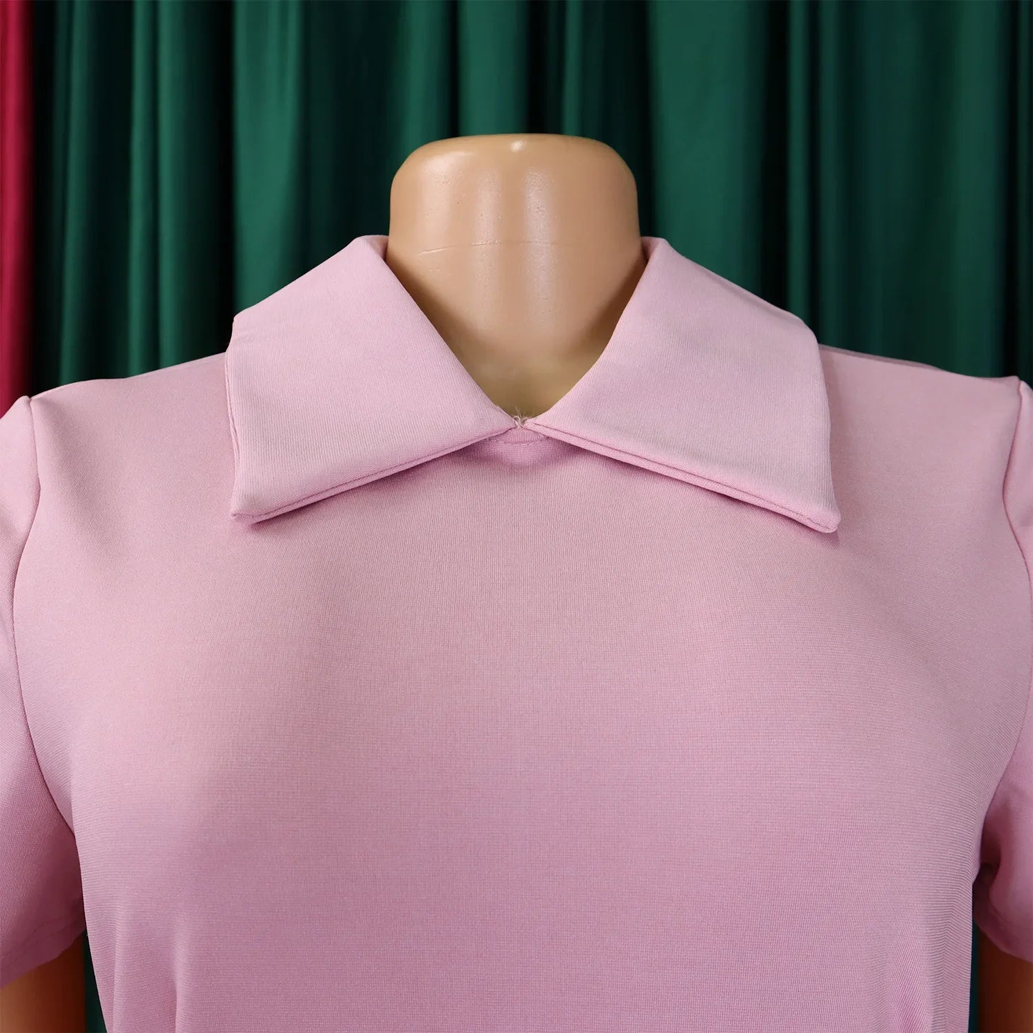 Model wearing an elegant high-waisted pleated evening dress with a Peter Pan collar, embodying timeless sophistication ideal for special occasions.