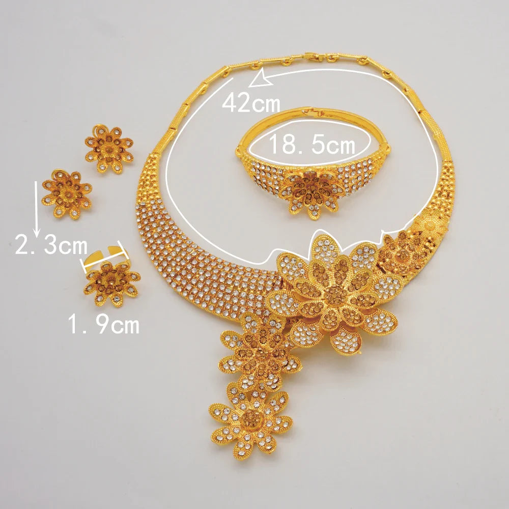 Complete luxury Dubai gold jewellery set for women displayed artistically, including necklace, earrings, bracelet, and ring.