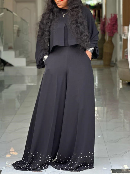 Close-up view of the intricate embroidery on the lantern sleeves of the women's elegant outfit, showcasing the fine details of this high-fashion ensemble.