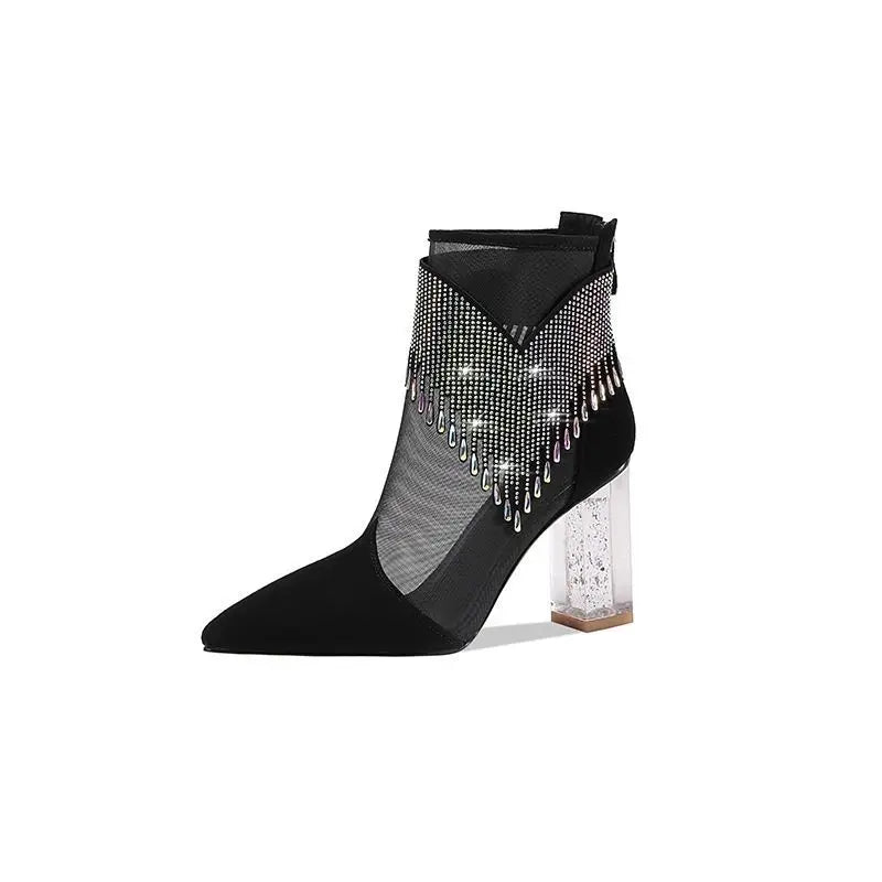 Close-up of a woman's luxurious pointed toe high heel boot with sparkling rhinestones, showcasing intricate tassel details and stylish lace-up design.