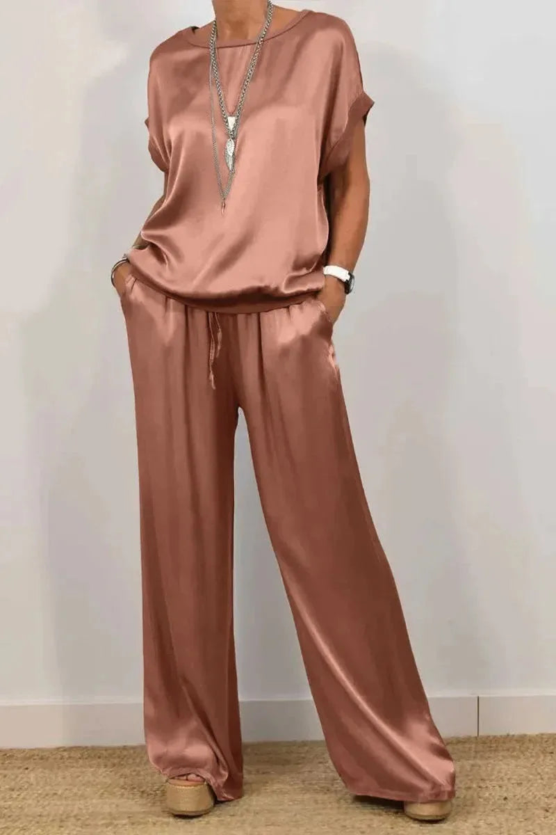 Stylish and loose fit summer outfit for women, featuring a luxurious satin t-shirt with pockets and matching wide leg pants.