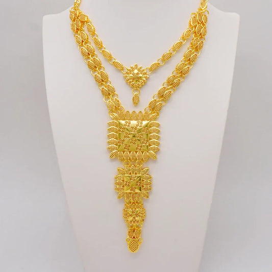 Close-up view of a luxurious women’s jewelry set in gold tones, showcasing a stylish necklace, matching earrings, bracelet, and ring, highlighting intricate craftsmanship and trendy square patterns.