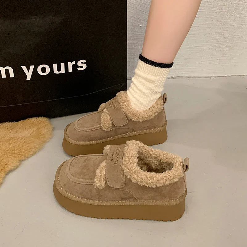 Sleek black ankle snow boots with height-increasing heel, designed for women, emphasizing a trendy and luxurious winter footwear choice.