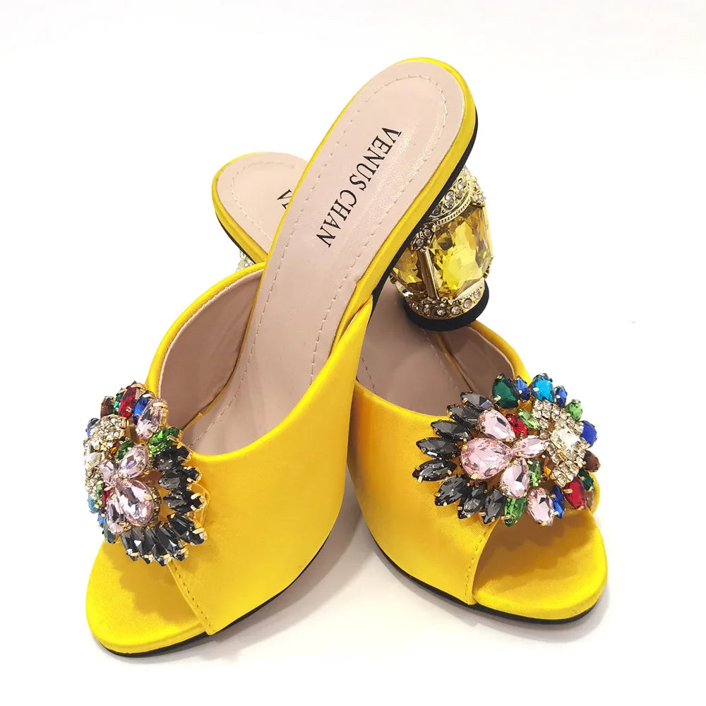 Close-up of yellow rhinestone detailing on luxurious stiletto heels, ideal for elegant evening events and special occasions.