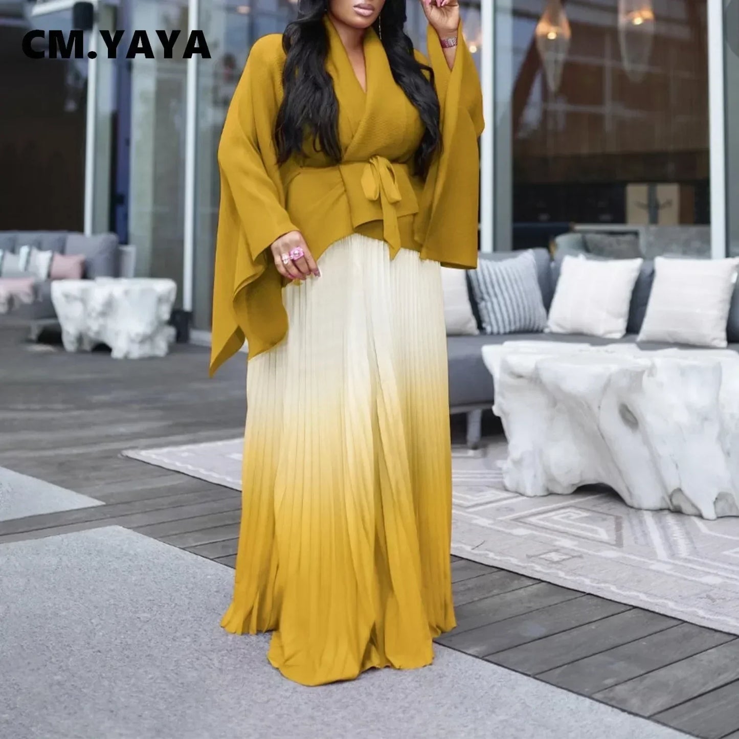 Graceful display of CM.YAYA's floor-length pleated long skirt, tailored for timeless style and autumn/winter chic appeal.