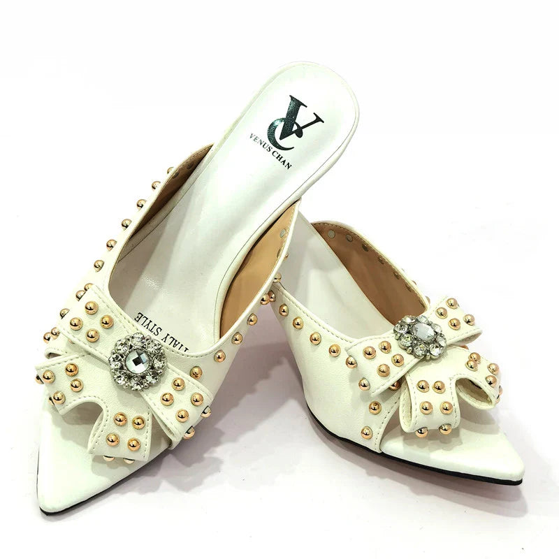 Sophisticated matching handbag set alongside high heeled shoes, showcasing a chic rivet design for the modern woman.