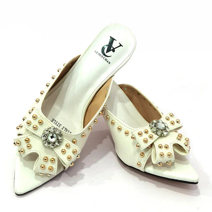 Sophisticated matching handbag set alongside high heeled shoes, showcasing a chic rivet design for the modern woman.