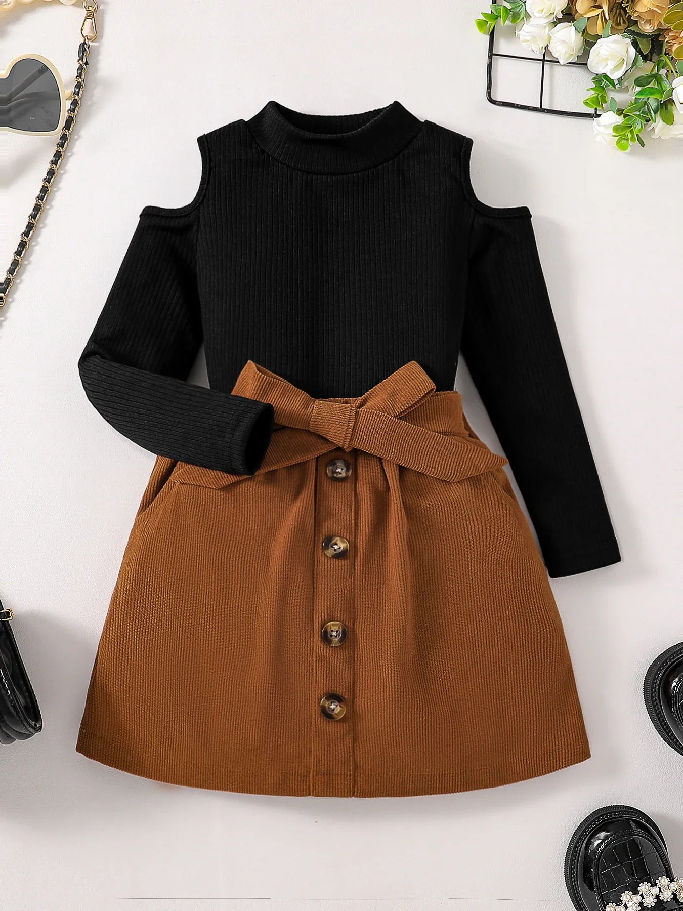 Close-up of the luxurious fabric and craftsmanship of the girls' off-shoulder turtleneck top, part of an autumn fashion set for ages 4-6.