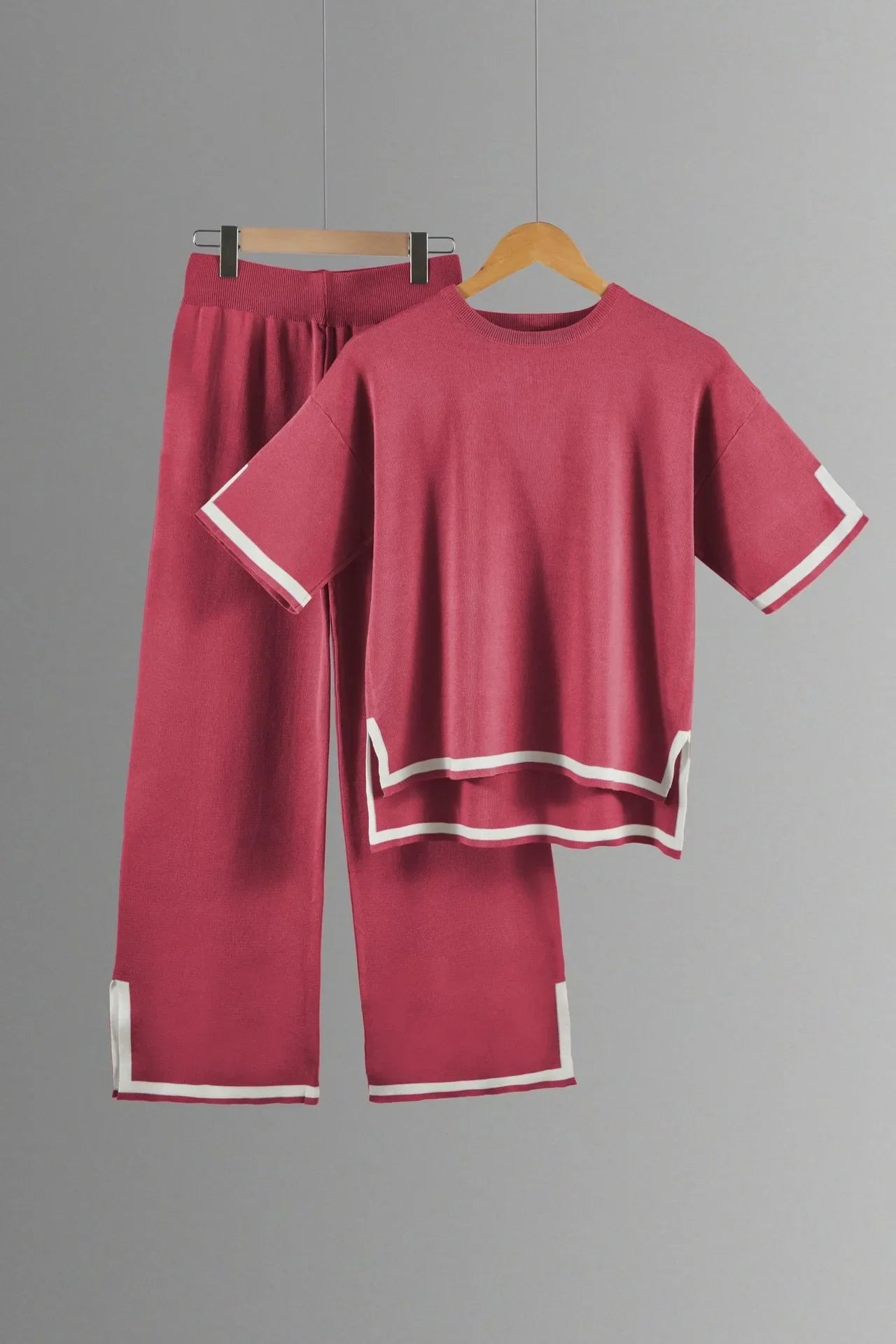 Elegant back view of a two-piece women's knitted suit showcasing its fashionable wide-leg pants and stylish short-sleeve pullover.