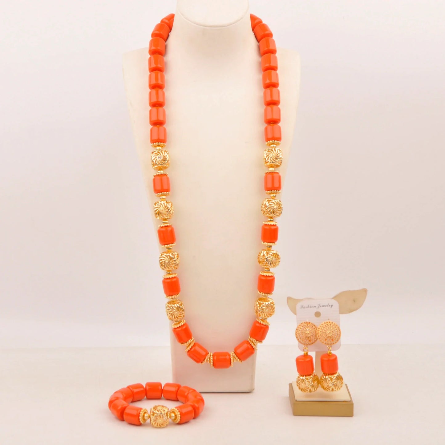 Elegant Nigerian bridal jewelry set featuring vibrant artificial coral beads, including a stunning necklace, chic bracelet, and exquisite earrings, perfect for weddings.
