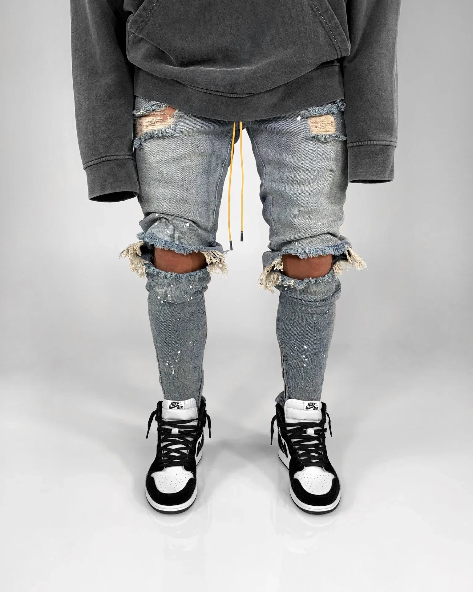 Full-length view of casual men's ripped hole jeans in blue, designed for comfort and style in any season.