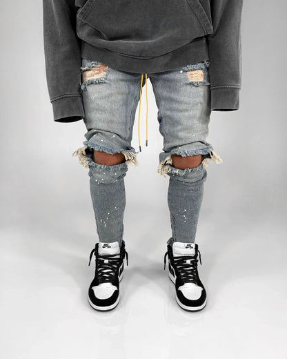 Full-length view of casual men's ripped hole jeans in blue, designed for comfort and style in any season.
