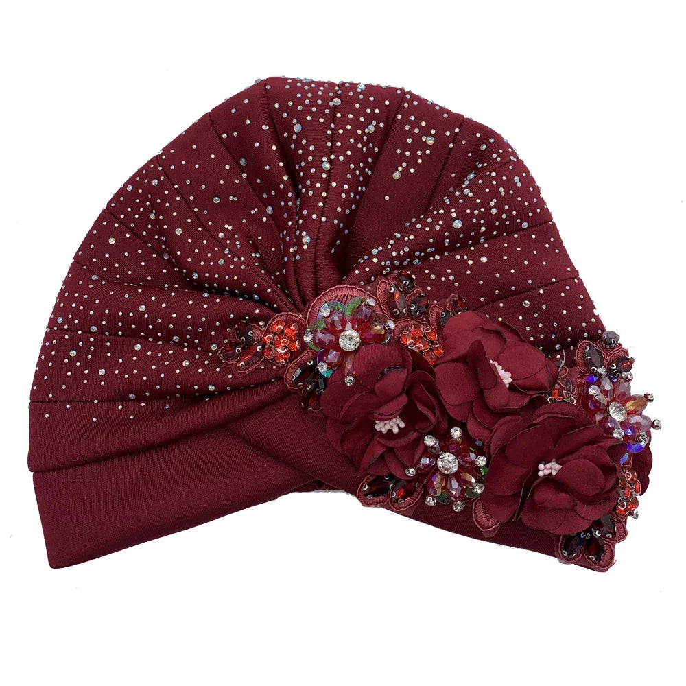 A beautifully styled African turban cap in a chic fashion, showcasing shimmering rhinestones and a regal fit, perfect as a luxurious head wrap.
