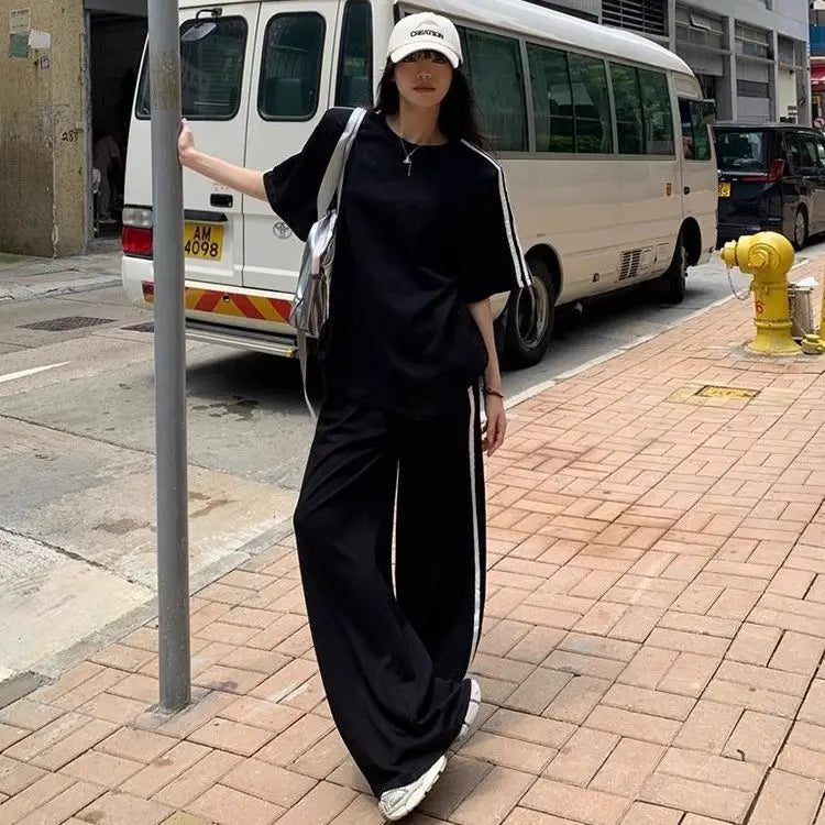 Fashionable detail of the spliced design on the striped T-shirt of the luxury women's two-piece set, highlighting its premium quality and sophisticated style.