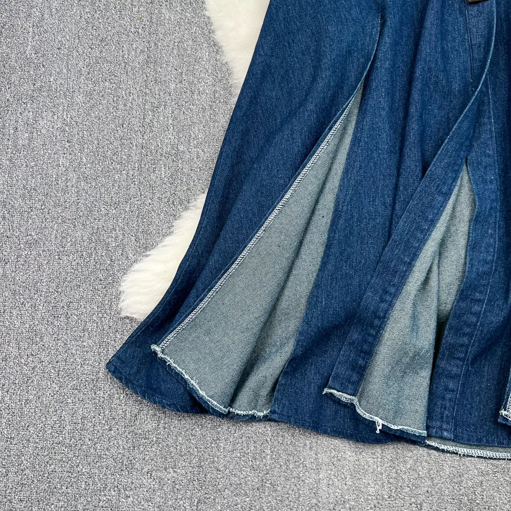 Mid-calf length sleeveless denim dress styled with a natural waistline, ideal for autumn and winter fashion.