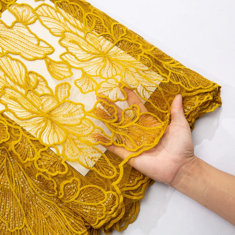 Close-up view of luxurious embroidered tulle fabric featuring delicate lace patterns and sparkling sequins, ideal for high-end wedding attire and sophisticated styles.