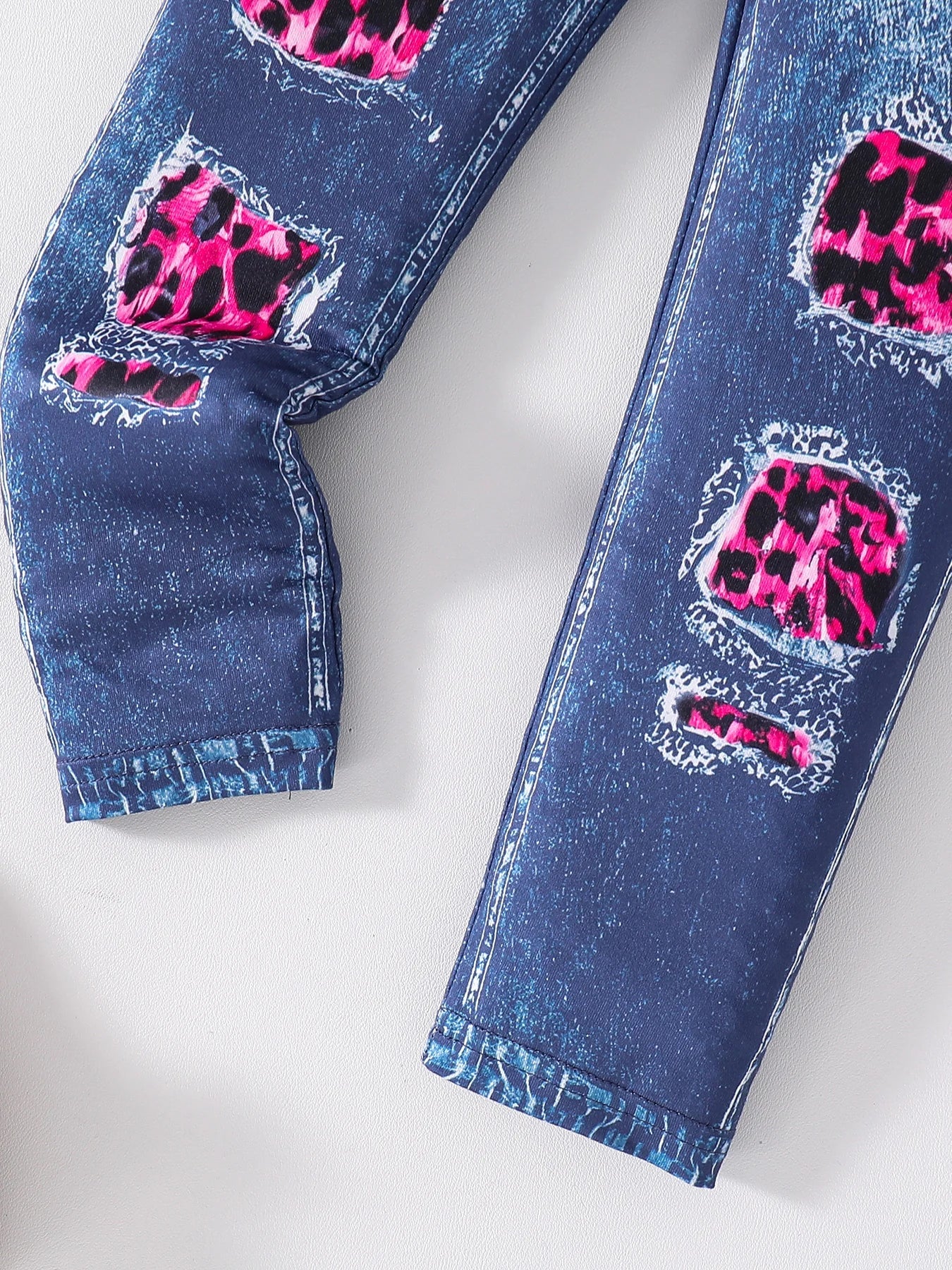 Complete outfit display of the girls 2-piece fashion set including a stylish pink leopard print long sleeve top and coordinating dark blue slim pants, ideal for fashionable children aged 4-6.
