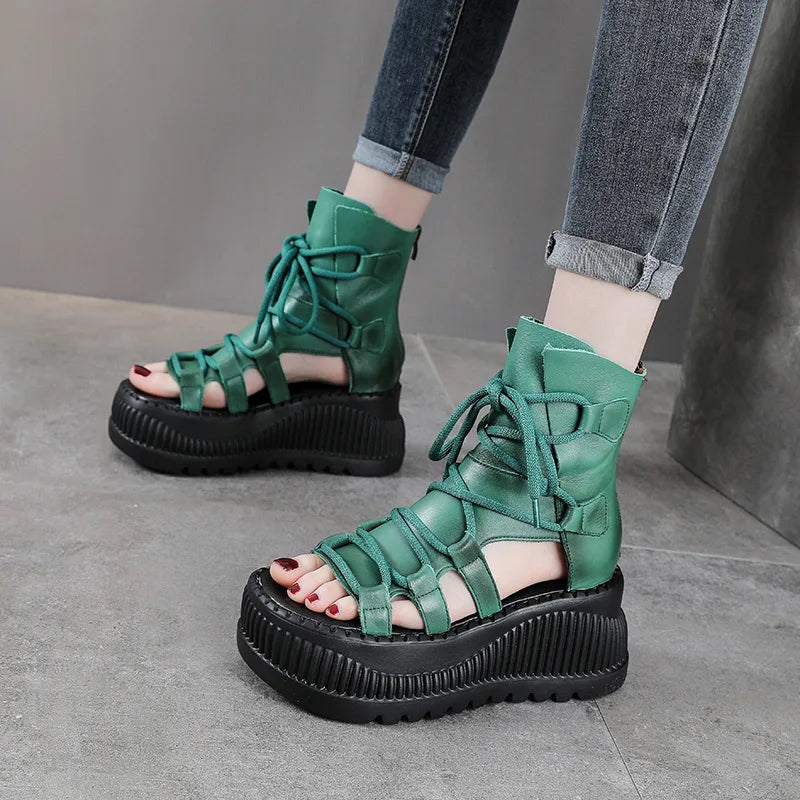 Detailed view of Koznoy women's peep toe wedge ankle booties crafted from genuine cow leather, highlighting intricate ethnic patterns and a stylish zipper closure.