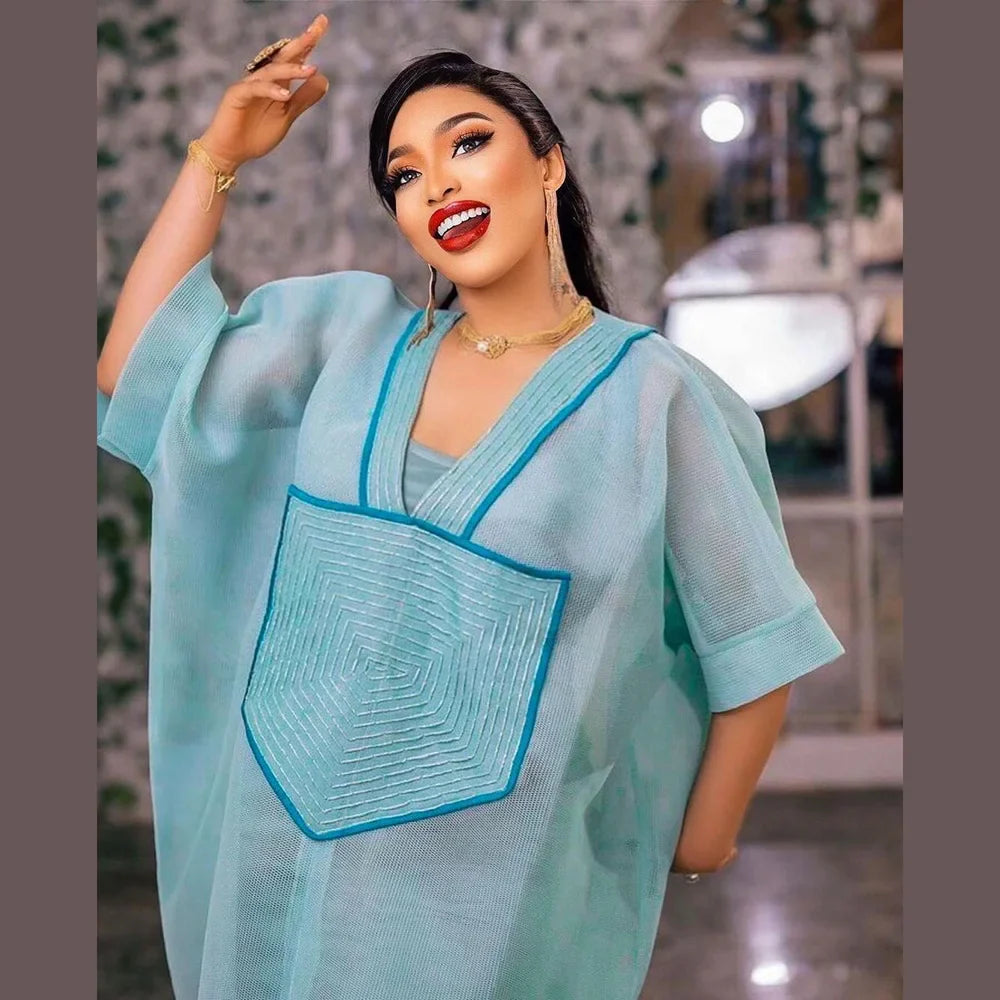 Chic African fashion women’s deep V-neck dress in luxurious blue with sophisticated mesh and embroidery details.