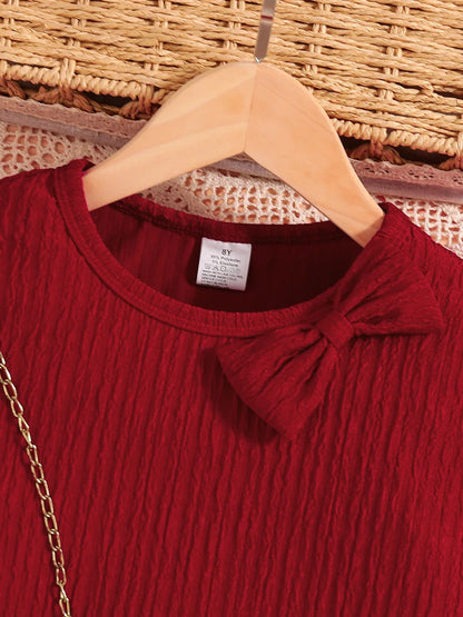 Close-up view of the luxurious red knitted dress for girls, showcasing the intricate bow detail at the neckline, ideal for stylish autumn outings.