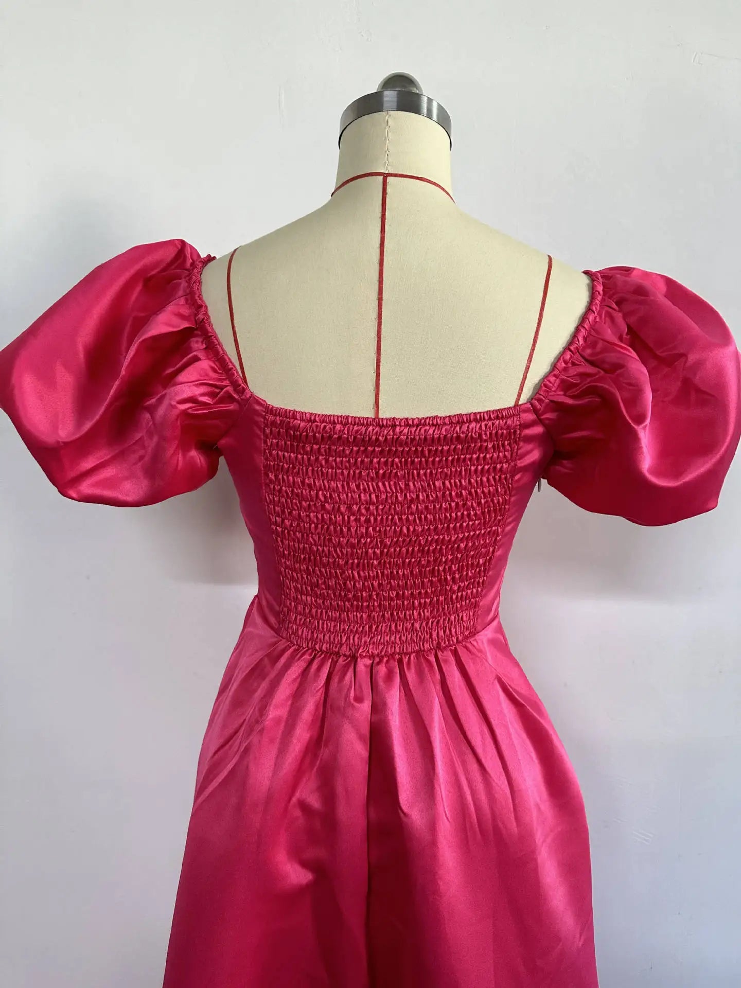 Back view of a women’s A-Line midi dress in deep pink with a charming backless design, ideal for glamorous events and parties.