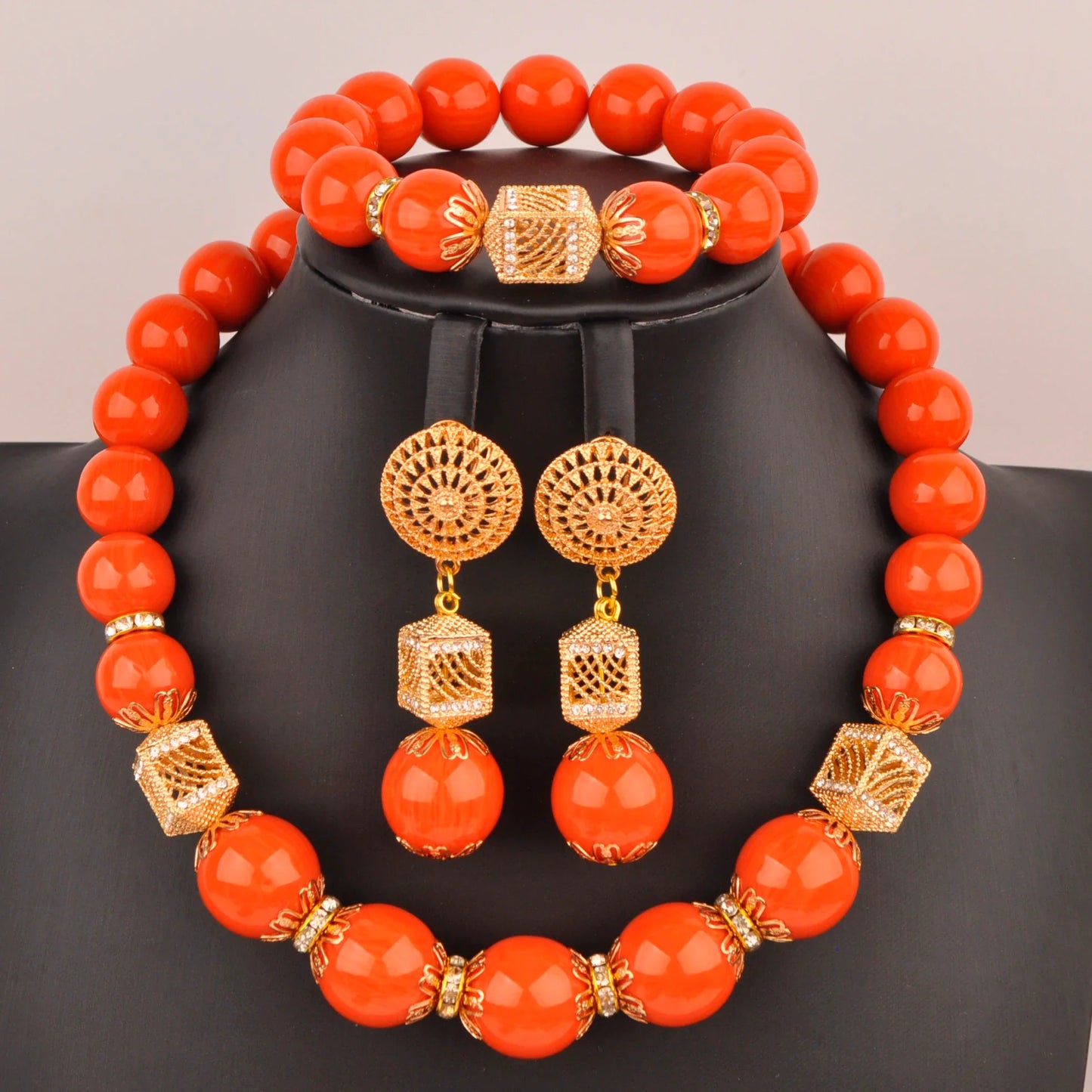 Elegant Nigerian bridal jewelry set featuring a stunning necklace, bracelet, and earrings adorned with vibrant artificial coral beads, perfect for weddings.