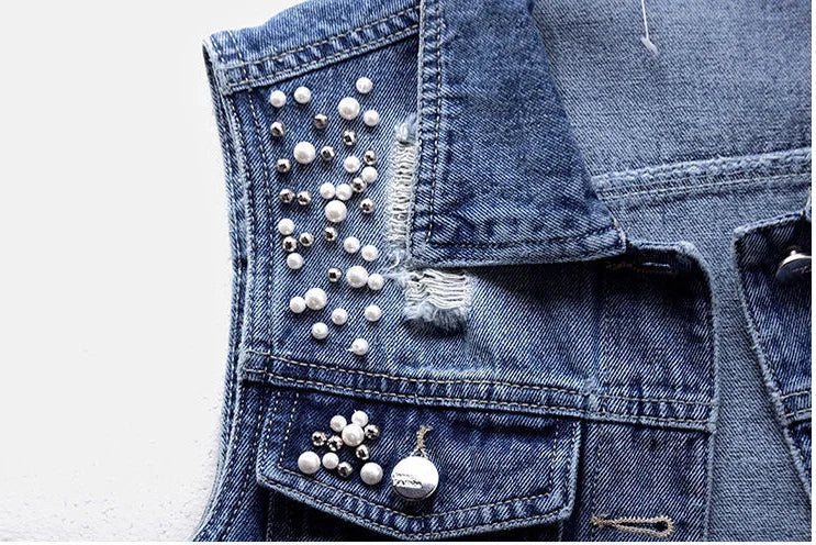 Sophisticated women’s sleeveless denim jacket with pearl embellishments, designed for a luxurious and casual autumn look.