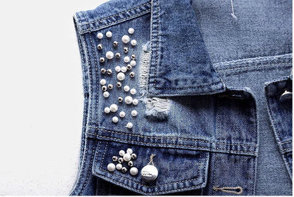 Sophisticated women’s sleeveless denim jacket with pearl embellishments, designed for a luxurious and casual autumn look.