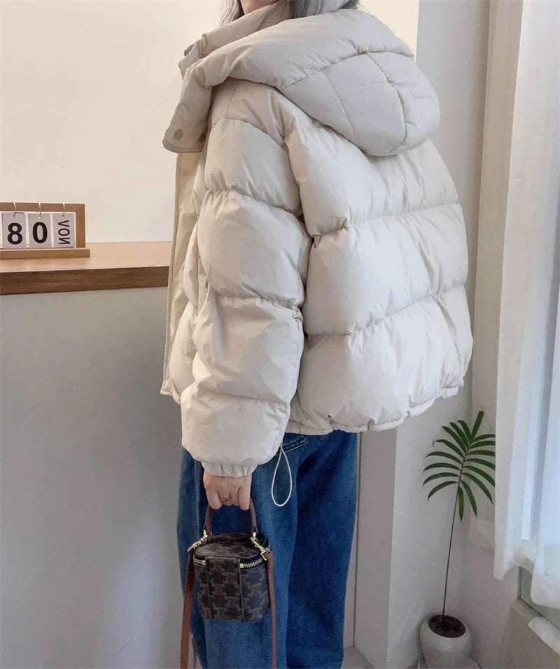 Elegant women's long sleeve casual parka featuring a stylish hood, thick padding, and refined zippers, perfect for chic winter outings.