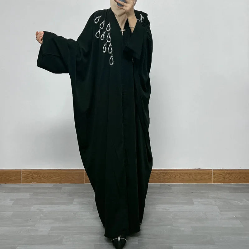 Model wearing a luxurious bat sleeve abaya showcasing elegant sequins, epitomising modern Muslim fashion for festive celebrations.