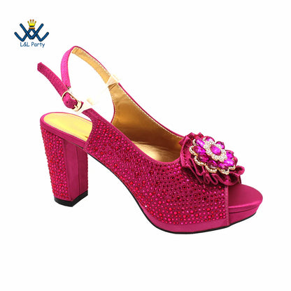 Chic magenta peep toe pumps with a secure buckle strap and dazzling crystal decor, an elegant choice for party attire.