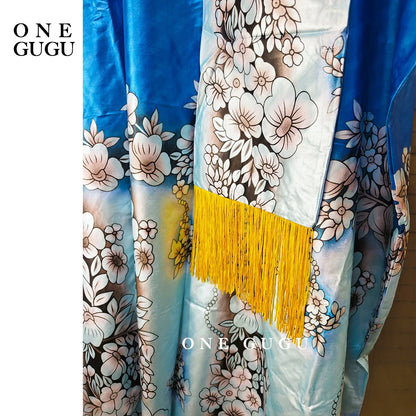 Elegant Luxury African Dashiki Wedding Dress in Blue Bazin Riche featuring intricate embroidery lace and stones, styled with a matching tassel shawl, perfect for women at weddings and special occasions.