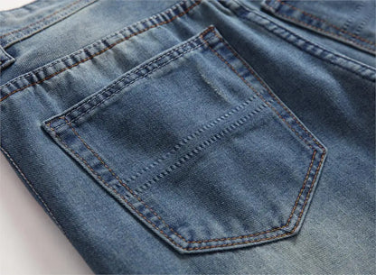 Elegant men's denim trousers with a modern stonewashed finish and unique hole decoration, embodying urban sophistication and contemporary fashion trends.